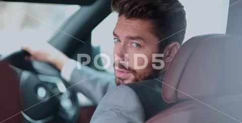 Portrait of an handsome smiling business man driving his car Stock Photos