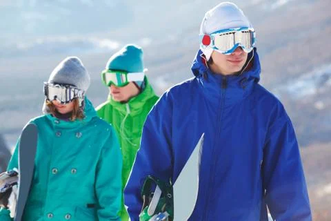 Portrait of handsome snowboarder in googles on background of his friends Stock Photos