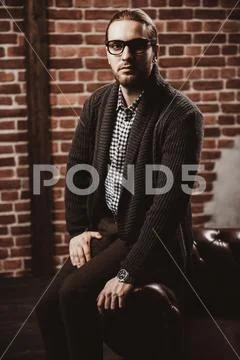 A portrait of a handsome stylish man posing in interior. Fashion for men. Int Stock Photos