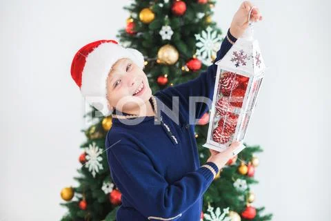Portrait of handsome white kid wearing blue sweater and red santa hat Stock Photos
