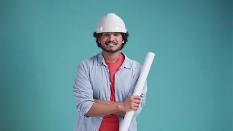 Portrait of a handsome young brunette engineer who is holding a drawing paper Stock Footage 240753595