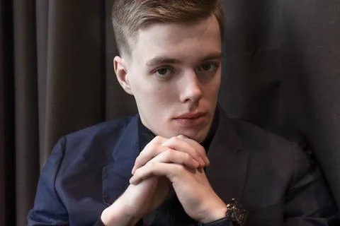 Portrait of a handsome young man in a classic suit sitting on a chair Stock Photos