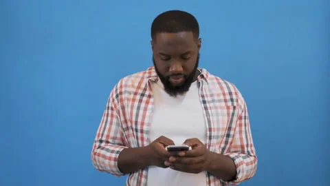 Portrait of handsome young man looking at his phone and smiling, he got message Stock Footage 117510198