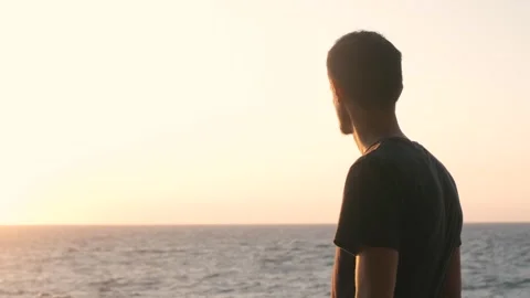 Portrait of handsome young man looking on seaside sunrise Stock Footage 250489215