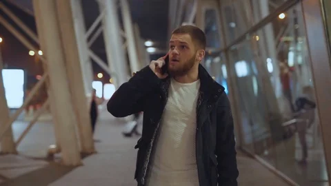 Portrait of handsome young man talking on mobile phone communicating walking on Stock Footage 117429597