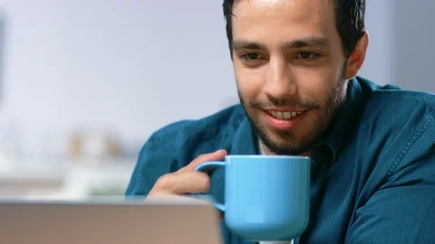 Portrait of Handsome Young Man Using Laptop Computer at Home, Watching and Laugh Video stock 97517866