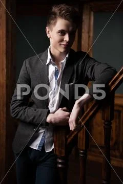 A portrait of a handsome young man wearing formal clothes and posing indoor. Stock Photos