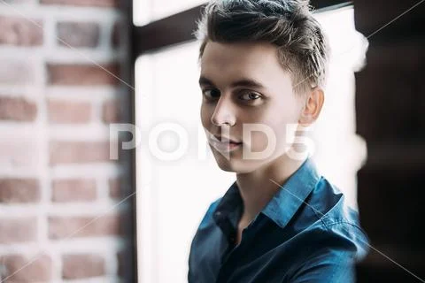 A portrait of a handsome young man wearing a blue shirt and posing indoor. Me Stock Photos