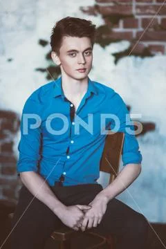 A portrait of a handsome young man wearing a blue shirt and posing indoor. Me Stock Photos