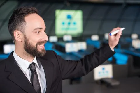 Portrait of a handsome young man write something with marker while standing in t Stock Photos
