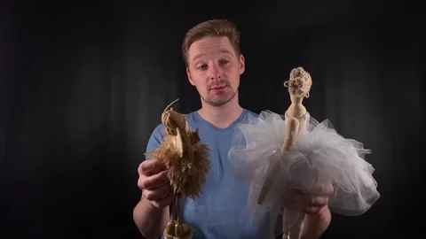 A portrait of a handsome young white man holding puppets, playing with them Stock Footage 274898172