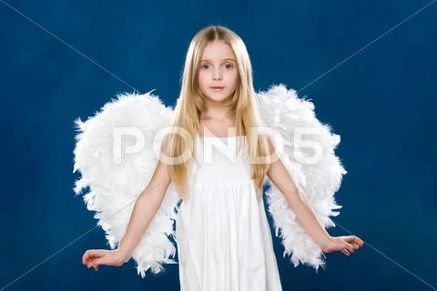 Portrait of happy angel wearing white clothing and wings over blue background Stock Photos