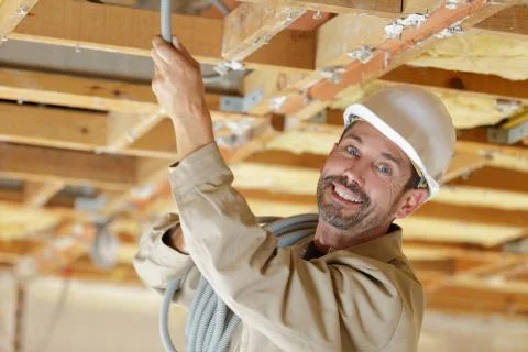 Portrait of a happy builder installing cables Stock Photos