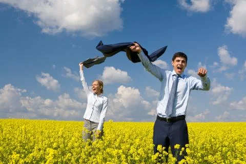 Portrait of happy business partners enjoying life and freedom in yellow field Stock Photos