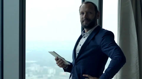 Portrait of happy businessman with tablet computer by window in office Stock Footage 88868405