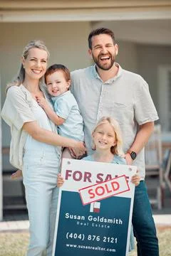 Portrait of happy caucasian family holding for sale and sold sign while Stock Photos