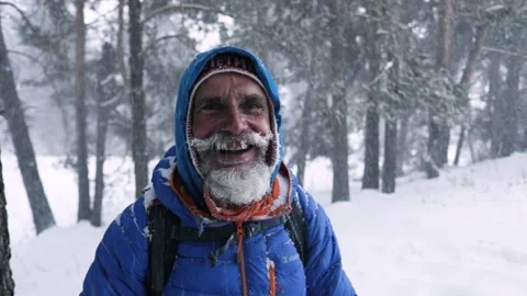 Portrait of happy climber with backpack at snowfall Stock Footage 166034078