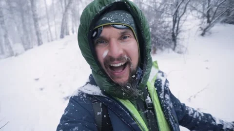 Portrait of happy climber with backpack at snowfall Video stock 166034474