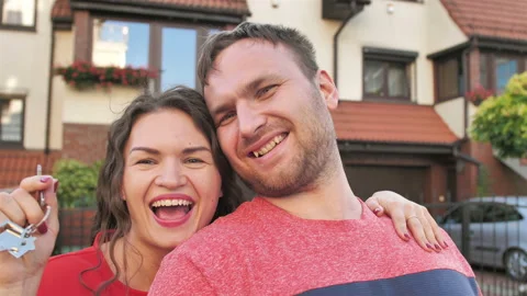Portrait Of Happy Couple Standing Outside New Home With Keys Stock Footage 114072753