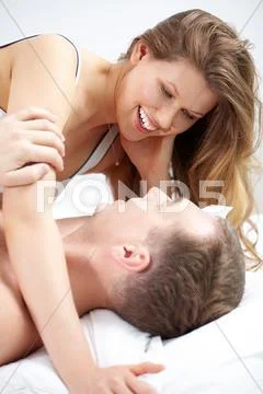 Portrait of a happy couple stroking in bed Stock Photos