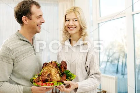 Portrait of happy couple with turkey looking at camera and smiling Stock Photos