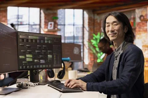 Portrait of happy CTO manager using PC in startup office to implement algorithms Foto stock