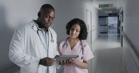 Portrait of happy diverse doctors using tablet in hospital in slow motion Stock Footage 335985439