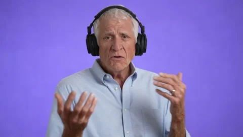 Portrait of happy elderly gray-haired man 70s in blue shirt listen music in Stock Footage 213283374