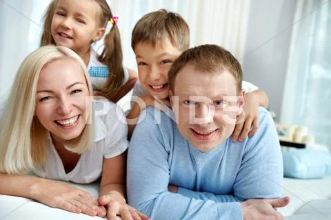 Portrait of happy family of four resting at home Stock Photos