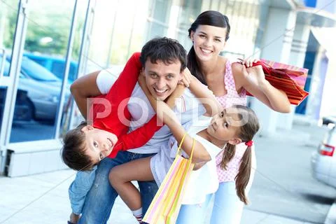 Portrait of happy family of four with shopping bags Stock Photos