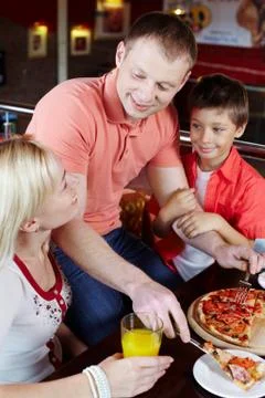 Portrait of happy family having lunch in pizzeria Stock Photos