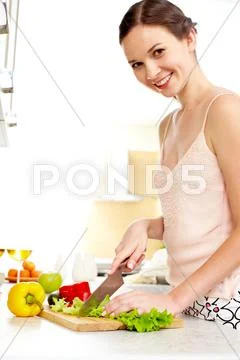 Portrait of happy female cooking vegetable salad Stock Photos