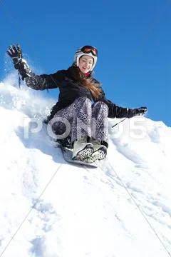 Portrait of happy girl riding on snowboard in winter Stock Photos