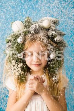 Portrait of happy girl standing under christmas snowfall and enjoying it Stock-Fotos
