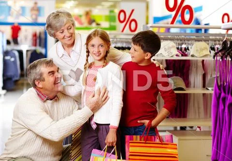 Portrait of happy grandparents and grandchildren in clothing department Stock Photos