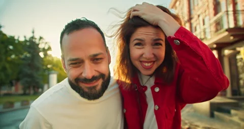 Portrait of a happy guy with a beard and a cheerful brunette girl looking at the Stock Footage 280601893