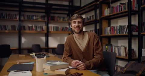 Portrait of a happy guy with a mustache and beard who sits at the table and Stock Footage 313357500