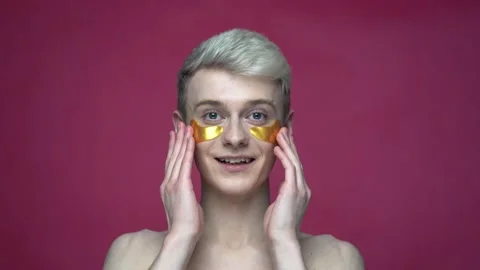 Portrait of happy guy transgender using trendy golden eye patches at home Stock-Footage 155462211