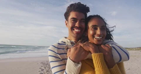 Portrait of happy hispanic couple standing and embracing on beach Stock Footage 344315470