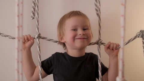 Portrait of happy little boy posing at rope ladder having positive emotion Stock Footage 125437116