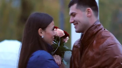 Portrait of Happy lovers in love in park. happy and embarrassed girl hugs a guy Stock Footage