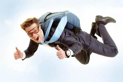 Portrait of happy man flying with parachute and showing thumbs up Stock Photos