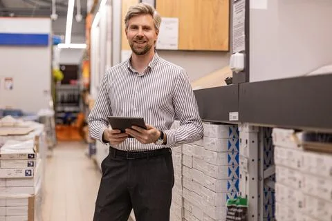Portrait of happy man using digital tablet in hardware store Stock Photos