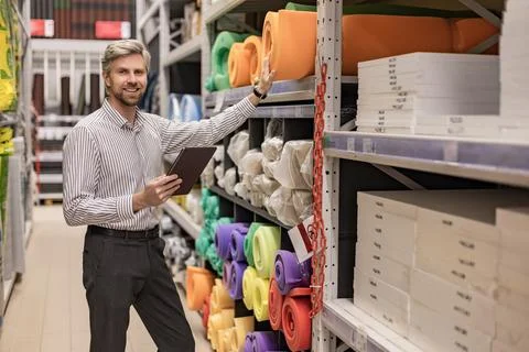 Portrait of happy man using digital tablet in hardware store 스톡 사진