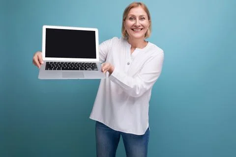 Portrait of happy middle aged business woman with blond hair using laptop with Stock Photos