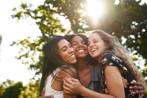 Portrait of a happy multiethnic group female friends hugging and embracing each Stock Photos