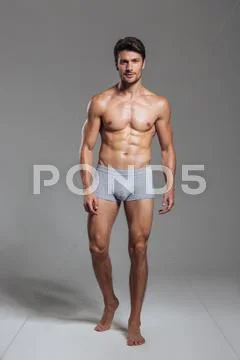 Portrait of a happy muscular man in underwear standing Stock Photos