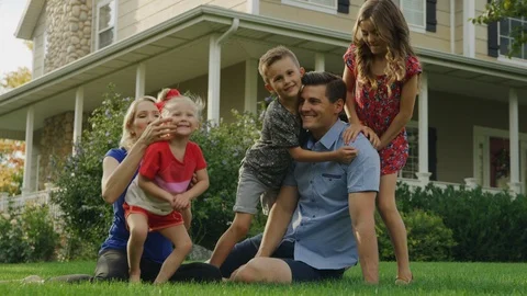 Portrait of happy playful family relaxing on lawn near house / Pleasant Grove, Stock Footage