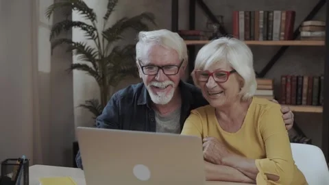 A portrait of a happy senior couple using computer at home Stock Footage 140867647