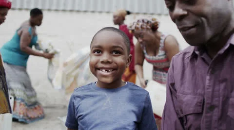 Portrait of happy smiling african boy with his family and community members Stock Footage
